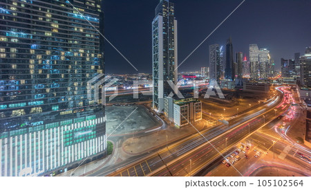 Many towers and skyscrapers with traffic on streets in Dubai Downtown and financial district night timelapse. 105102564
