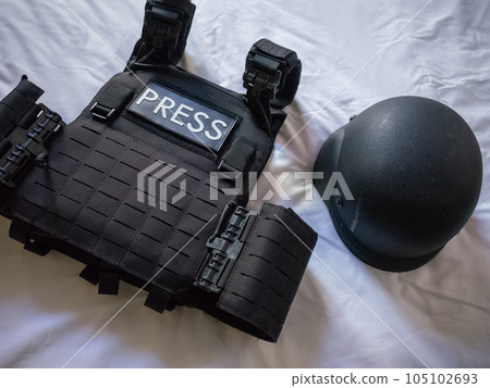 [Ukraine] A black bulletproof vest and helmet on a bed in a hotel in Kyiv 105102693