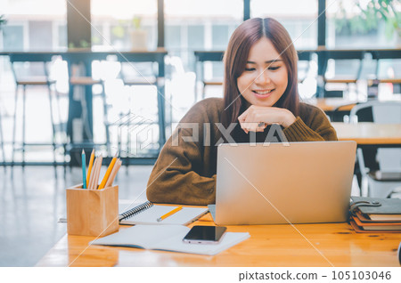 young student wearing headphones studies online, distance learning, and keeps up to date on the global coronavirus pandemic.. 105103046