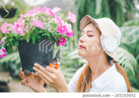 Young women doing hobbies taking care of plants, watering, shoveling flowers. In the garden during the break from work 105103052