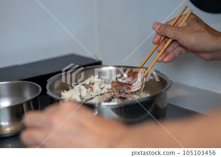 A man's hand loosening a sea bream of sea bream rice made in a pressure cooker A man's hand loosening a sea bream of sea bream rice made in a pressure cooker 105103456