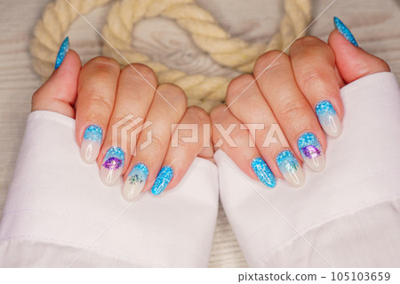 Manicure in the marine style.  Photos with beautiful well-groomed female nails. Selective focus. 105103659