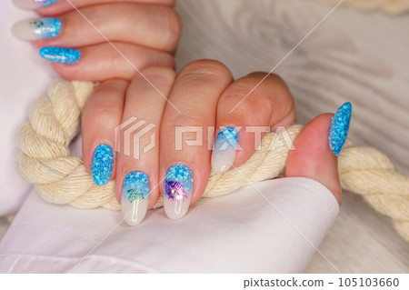 Manicure in the marine style.  Photos with beautiful well-groomed female nails. Selective focus. 105103660