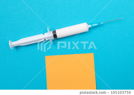 Vaccination or Revaccination Concept - A Medical Syringe on Blue Table 105103750