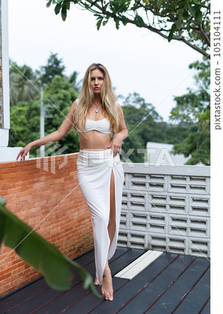 Beautiful young blonde woman in a top and a white skirt with long hair and smooth skin, fashionable, stylish, posing outdoor, natural beauty, day light Beautiful young blonde woman in a top and a white skirt with long hair and smooth skin, fashionable, stylish, posing outdoor, natural beauty, day light 105104111