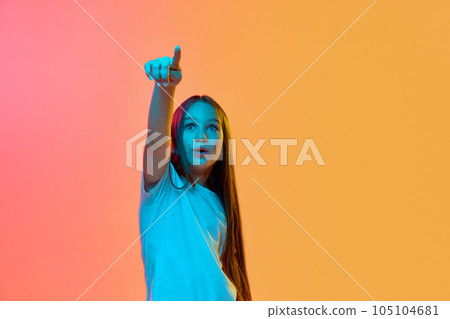 Surprised emotional school age girl, child wearing casual style clothes over neon light background. Concept of childhood, emotions, kids fashion Surprised emotional school age girl, child wearing casual style clothes over neon light background. Concept of childhood, emotions, kids fashion 105104681