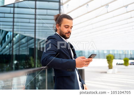Businessman standing outdoor use smartphone 105104705