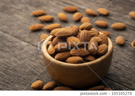 Dry roasted Almonds in wooden bowl on wooden table.Heap of almond. Dry roasted Almonds in wooden bowl on wooden table.Heap of almond. 105105278
