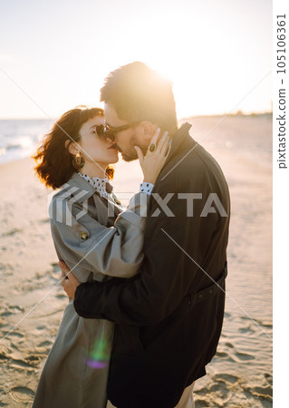 Stylish couple walking and hugging by the sea. Springtime. Relaxation, youth, love, lifestyle. Stylish couple walking and hugging by the sea. Springtime. Relaxation, youth, love, lifestyle. 105106361