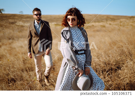 Stylish and loving couple enjoying each other outdoors. Stylish couple walking and hugging. Stylish and loving couple enjoying each other outdoors. Stylish couple walking and hugging. 105106371