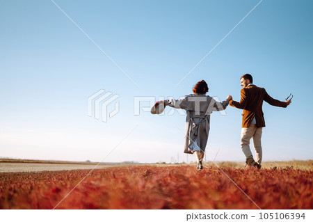 Young couple walks in the park during the spring and hugs. Enjoying time together. 105106394