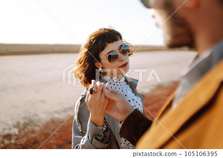 Young couple walks in the park during the spring and hugs. Enjoying time together. 105106395