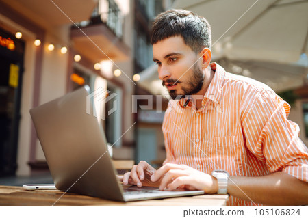 Man with laptop and phone sits in cafe and works. Business, blogging, freelance, education concept. Man with laptop and phone sits in cafe and works. Business, blogging, freelance, education concept. 105106824