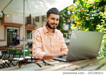 Man with laptop and phone sits in cafe and works. Business, blogging, freelance, education concept. Man with laptop and phone sits in cafe and works. Business, blogging, freelance, education concept. 105106831