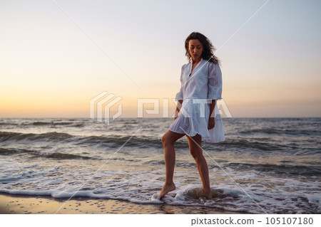 Stylish woman in elegant white dress posing near the sea. Summer time. Travel, weekend, relax. Stylish woman in elegant white dress posing near the sea. Summer time. Travel, weekend, relax. 105107180