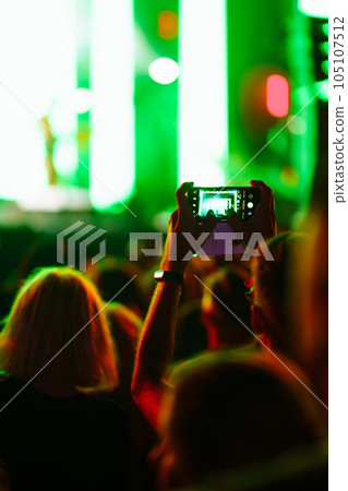 Hand with a phone records live music festival. People taking photographs with smart phone. Hand with a phone records live music festival. People taking photographs with smart phone. 105107512