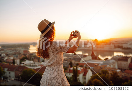 Travel in Europe. Young woman enjoys sunrise. The concept of travel, tourism, vacation and freedom. 105108132