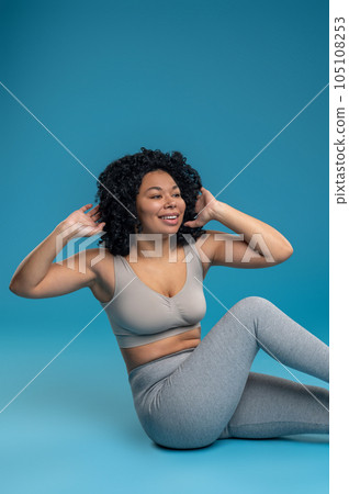 Young curly-haired woman working on her abs 105108253