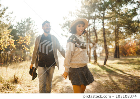 Lovely hipster couple looking at each other. Couple wearing beautiful hats and sweaters. 105108374