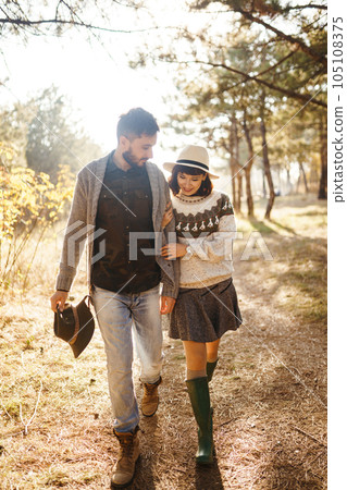 Lovely hipster couple looking at each other. Couple wearing beautiful hats and sweaters. Lovely hipster couple looking at each other. Couple wearing beautiful hats and sweaters. 105108375