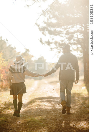 Lovely hipster couple looking at each other. Couple wearing beautiful hats and sweaters. Lovely hipster couple looking at each other. Couple wearing beautiful hats and sweaters. 105108381