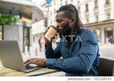 Dark-skinned young man working in a cafe outdoors 105108524
