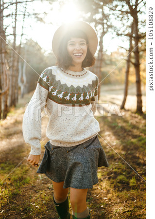 Lovely girl with a beautiful smile at sunset in the forest. The girl is dressed with a hat. Lovely girl with a beautiful smile at sunset in the forest. The girl is dressed with a hat. 105108829