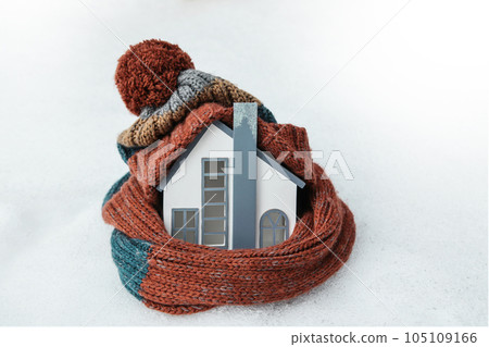 Alternative Energy. Heating system, cold snowy weather. Heat House wearing knitted cap 105109166