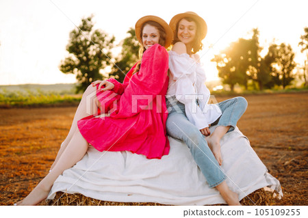 Two young women having fun near haystack. Fashion concept. Summer concept. Two young women having fun near haystack. Fashion concept. Summer concept. 105109255