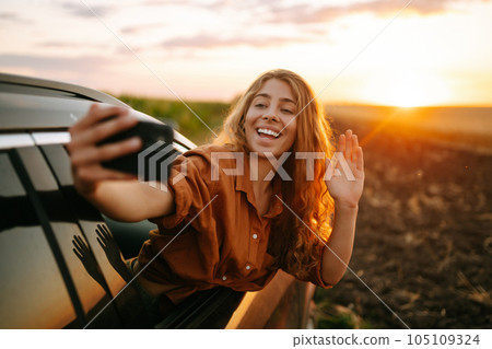 Selfie while traveling. Woman takes selfie in car during road trip. Lifestyle, travel, active life. Selfie while traveling. Woman takes selfie in car during road trip. Lifestyle, travel, active life. 105109324