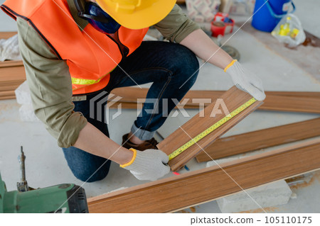 Structural worker dressed in safety gear and hard hat doing construction and using circular saw to work Structural worker dressed in safety gear and hard hat doing construction and using circular saw to work 105110175