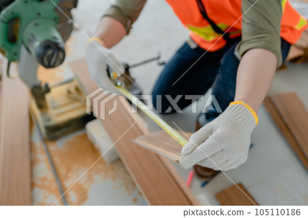 Structural worker dressed in safety gear and hard hat doing construction and using circular saw to work Structural worker dressed in safety gear and hard hat doing construction and using circular saw to work 105110186