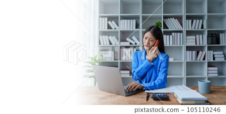 Busy businesswoman wearing a suit busy with work workaholic while sitting at work clear paperworks with documents and talk on the phone on your smartphone hear the hustle and bustle, busy concepts Busy businesswoman wearing a suit busy with work workaholic while sitting at work clear paperworks with documents and talk on the phone on your smartphone hear the hustle and bustle, busy concepts 105110246