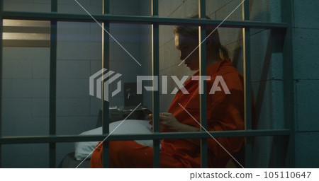 Female in prison using smartphone Female in prison using smartphone 105110647