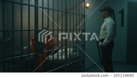 Prison officer walks the corridor, gives phone to female prisoner 105110690