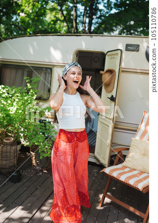 Happy hippie girl is having a good time in a camper trailer. Holiday, vacation, trip concept. Happy hippie girl is having a good time in a camper trailer. Holiday, vacation, trip concept. 105110786