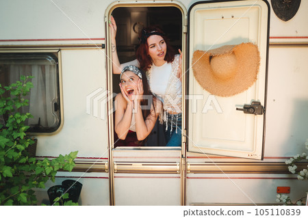 Happy hippie friends are having a good time together in a camper trailer. Holiday, vacation, trip concept. Happy hippie friends are having a good time together in a camper trailer. Holiday, vacation, trip concept. 105110839
