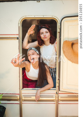Happy hippie friends are having a good time together in a camper trailer. Holiday, vacation, trip concept. Happy hippie friends are having a good time together in a camper trailer. Holiday, vacation, trip concept. 105110855