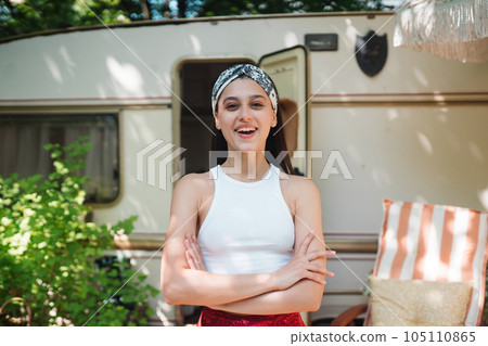 Happy hippie girl is having a good time in a camper trailer. Holiday, vacation, trip concept. Happy hippie girl is having a good time in a camper trailer. Holiday, vacation, trip concept. 105110865