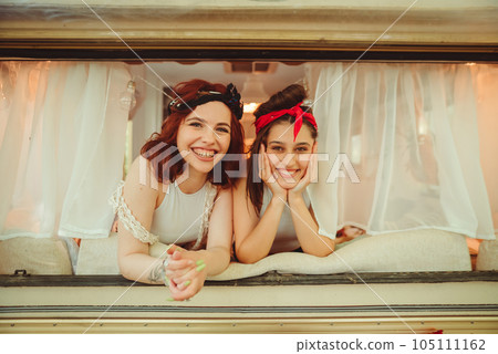 Happy hippie friends are having a good time together in a camper trailer. Holiday, vacation, trip concept. Happy hippie friends are having a good time together in a camper trailer. Holiday, vacation, trip concept. 105111162