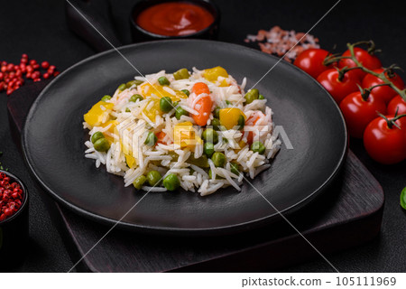 Delicious fresh white boiled rice with vegetables carrots, peppers and asparagus beans on a ceramic plate Delicious fresh white boiled rice with vegetables carrots, peppers and asparagus beans on a ceramic plate 105111969