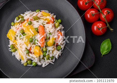 Delicious fresh white boiled rice with vegetables carrots, peppers and asparagus beans on a ceramic plate Delicious fresh white boiled rice with vegetables carrots, peppers and asparagus beans on a ceramic plate 105111970