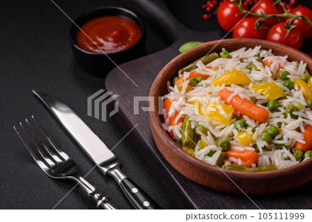 Delicious fresh white boiled rice with vegetables carrots, peppers and asparagus beans on a ceramic plate Delicious fresh white boiled rice with vegetables carrots, peppers and asparagus beans on a ceramic plate 105111999