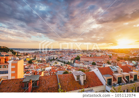 View of Lisbon famous view from Miradouro da Senhora do Monte tourist viewpoint of Alfama and Mauraria old city district, 25th of April Bridge at sunset. Lisbon, Portugal 105112074