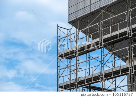Temporary scaffolding installed under the eaves of a building exterior wall construction project 105116757