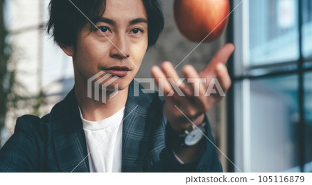 A man in his thirties has an apple A man in his thirties has an apple 105116879