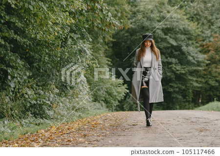 Girl walks. Woman in a gray coat. Brunette with a black cap. 105117466