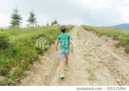 The Ukrainian boy goes up the mountain road forward. Motivating photo 105121064