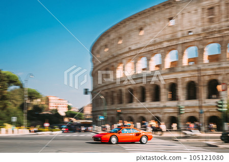 Rome, Italy. Red italian supercar Coupe In Fast Motion Near Colosseum 105121080