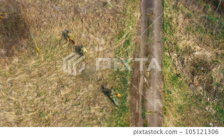 Men Dressed As US American Soldiers Of USA Infantry Of World War II sneaking around In spring Autumn Day. Soldiers prepare mortar for battle In dry grass. Aerial view elevated shot Men Dressed As US American Soldiers Of USA Infantry Of World War II sneaking around In spring Autumn Day. Soldiers prepare mortar for battle In dry grass. Aerial view elevated shot 105121306